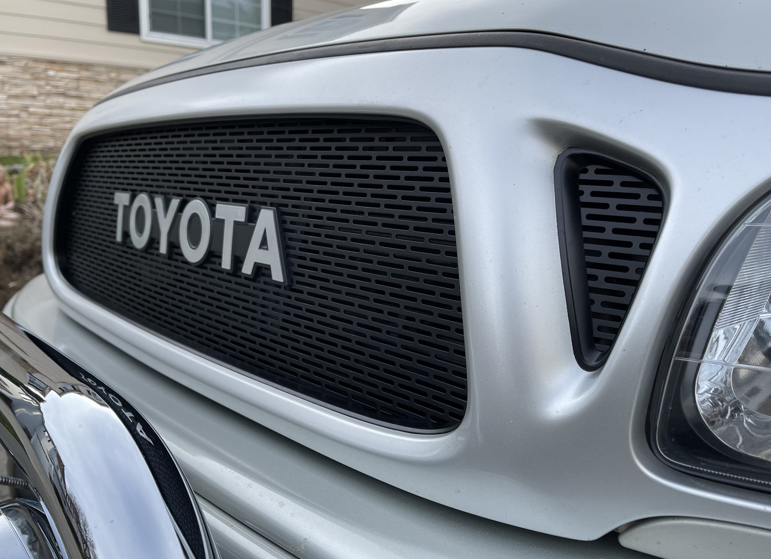 Upgrade Your Tacoma's Front End with a Custom Grille Featuring Slotted Mesh and a Silver Emblem